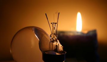 Kerze und kaputte Glühbirne bei Stromausfall